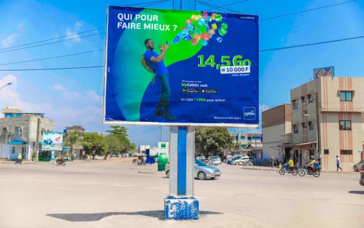 Grand panneau publicitaire sur mât unique en bordure de voie urbaine